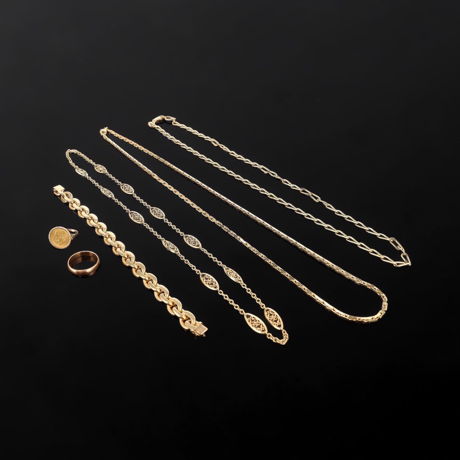 Lot en or 18K (750e) composé d’une alliance, d’une pièce en or sertie en bague, d’un collier à maille cheval, d’un collier à maille filigrane, d’un collier à maille forçat épaisse, ainsi que d’un bracelet de type gourmette aplatie.