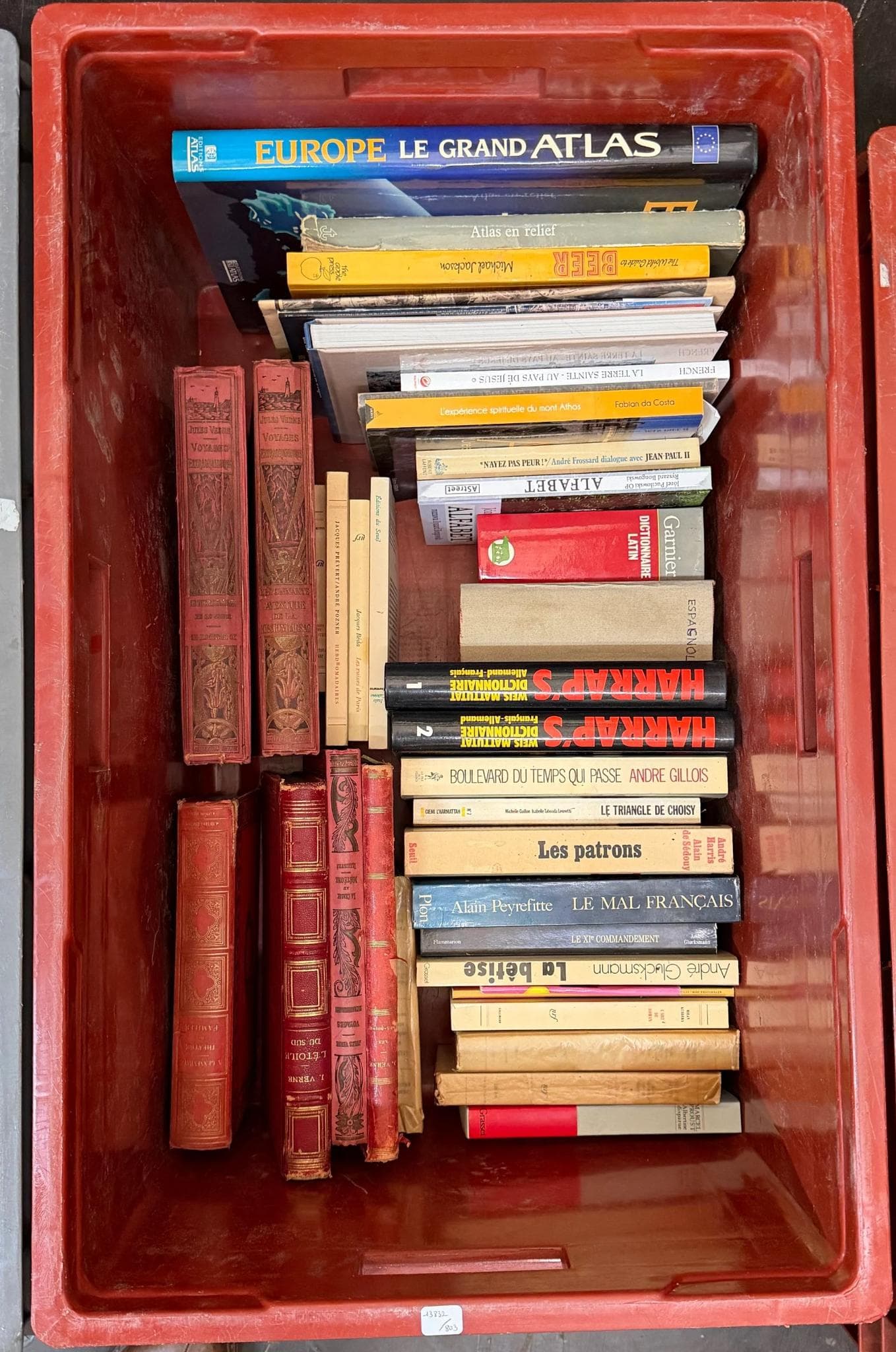 Littérature. Caisse d'ouvrages reliés et brochés, formats divers, titres visibles tels que 'EUROPE LE GRAND ATLAS', 'HARKIS, SOLDATS ABANDONNÉS', 'Les patrons', 'Le mal français', ainsi que plusieurs volumes en reliure décorée et des éditions brochées, état d'usage.