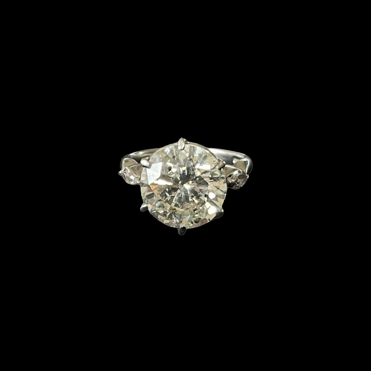 Bague solitaire en platine (850e), ornée d'un diamant taille brillant en serti griffe, épaulé de diamants taille navette.