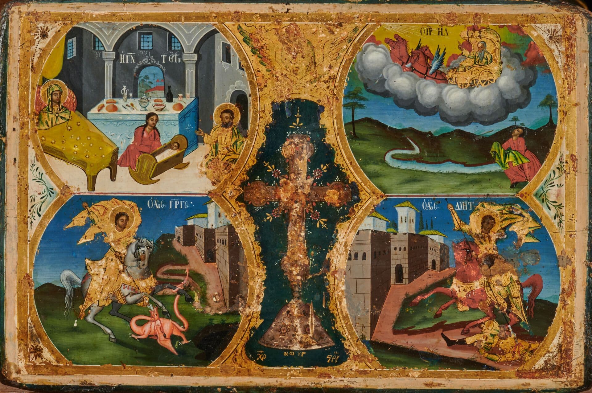 Icône à quatre scènes sur deux registres entourant un crucifix. Au premier la Nativité de la Mère de Dieu à gauche et l'Ascension de Saint Élie à droite ; au second les saints Georges et Dimitri sur leur cheval. Usures et petits manques.