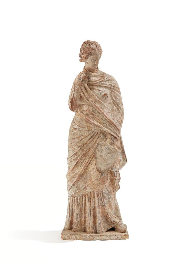 Statuette votive représentant une jeune femme drapée dans un himation.